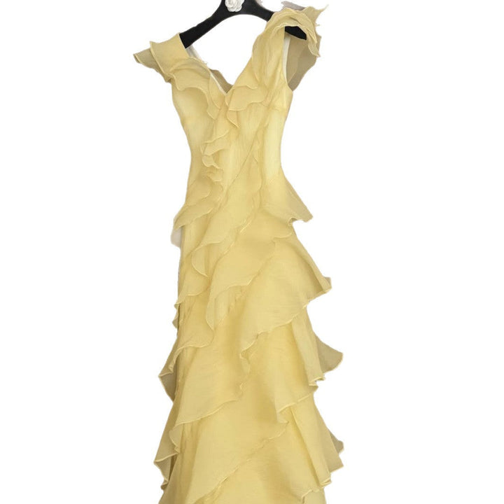 Stilren lysegul off-shoulder maxikjole med delikat vannfall volangdetalj. Ideell elegant damekjole.
