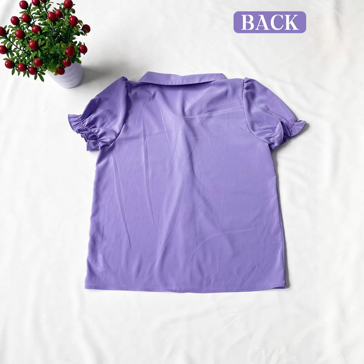 Komfortabel elegant damebluse i lilla med voluminøse puffermer og fine knappdetaljer. En klassisk sommertopp.