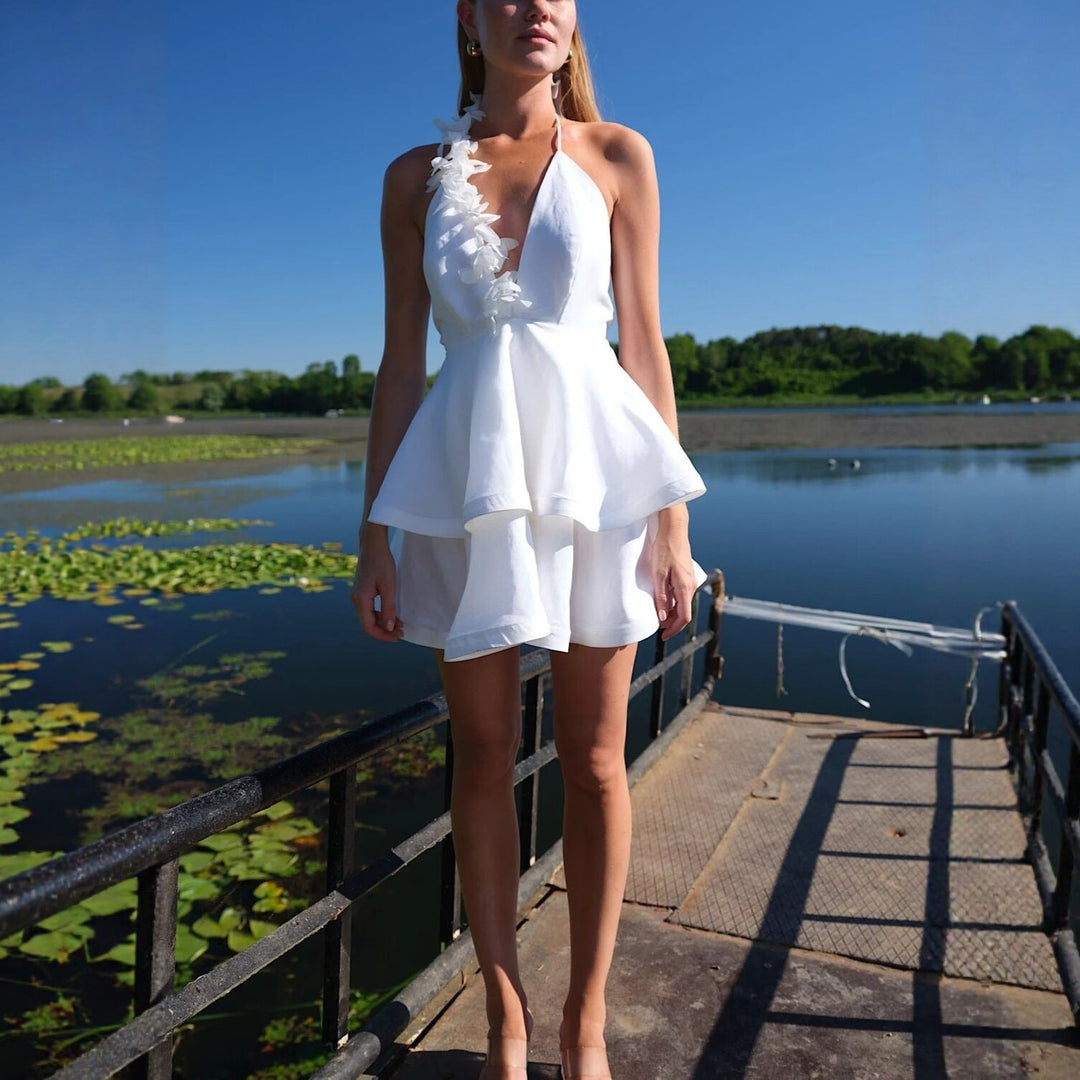 Elegant hvit sommerkjole med halterneck og voluminøst skjørt. Ideell for bryllup, hagefester og formelle events.