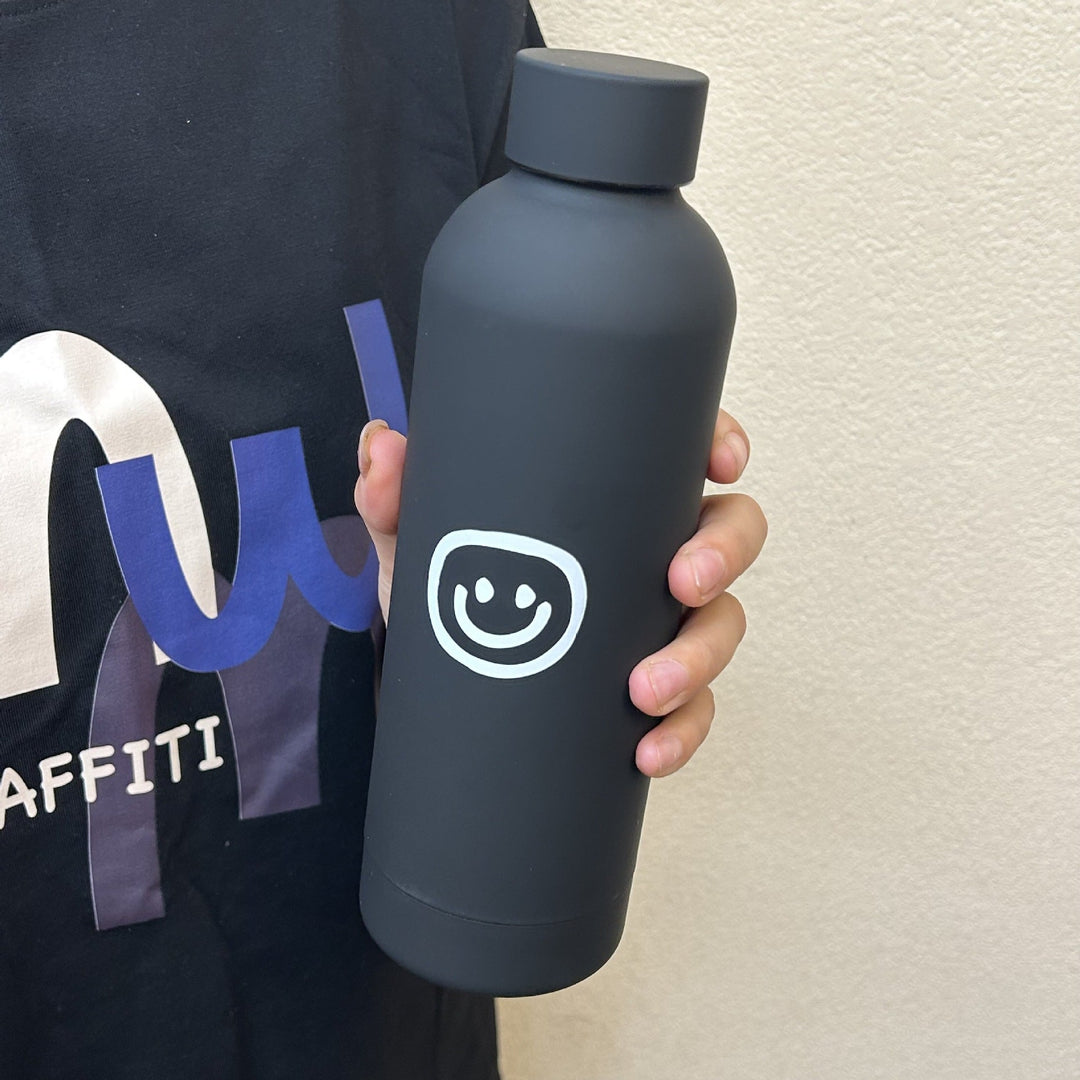Svart isolasjonsflaske 500ml med søtt smiley-ansikt. Lekkasjesikker og holder drikken varm/kald.