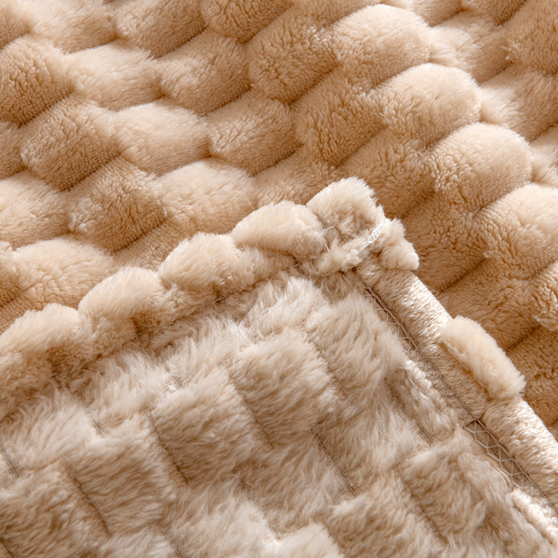 Nærbilde av detaljert tekstur på mykt beige fuskepelspledd, perfekt for en komfortabel atmosfære i interiøret.