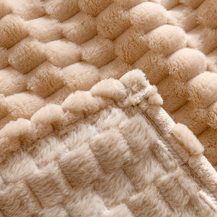Nærbilde av detaljert tekstur på mykt beige fuskepelspledd, perfekt for en komfortabel atmosfære i interiøret.