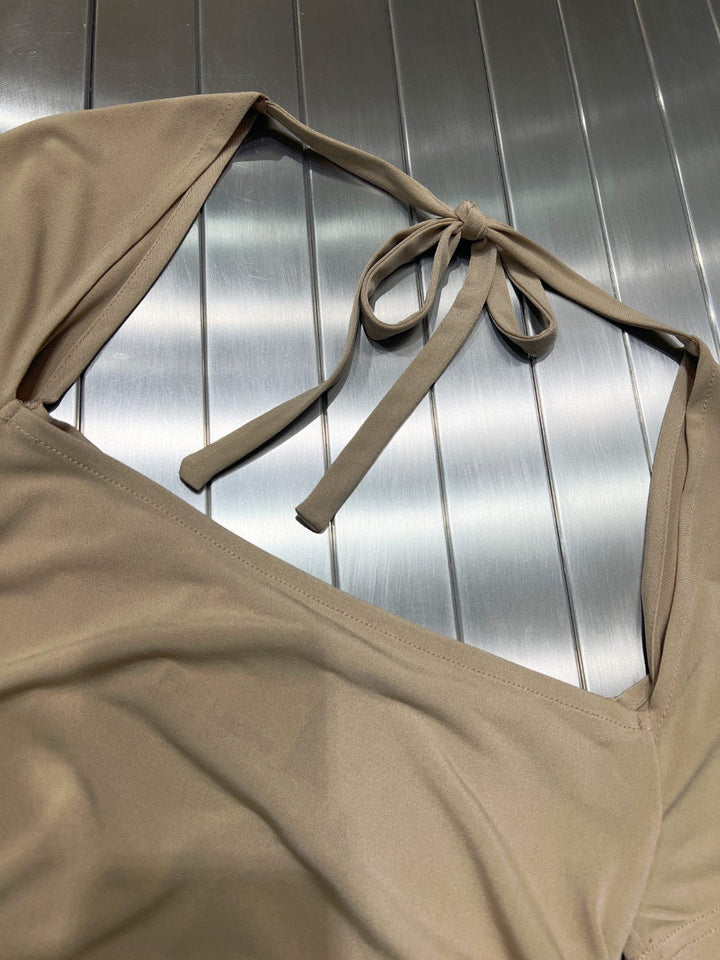 Elegant khaki damebluse med unik ryggutskjæring. Stretchmateriale gir perfekt passform, ideell for fest og hverdag.