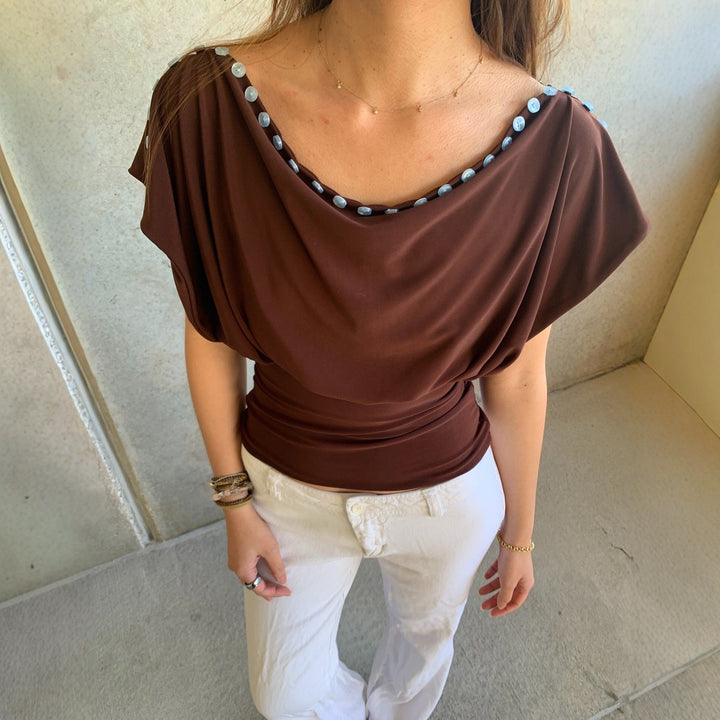 Brun elegant dame off-shoulder topp med delikate knapper. Perfekt festtopp eller hverdagsskjorte.