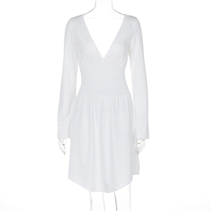 Modell iført ensfarget elegant damekjole med V-hals og lange ermer, perfekt som kveldsantrekk.