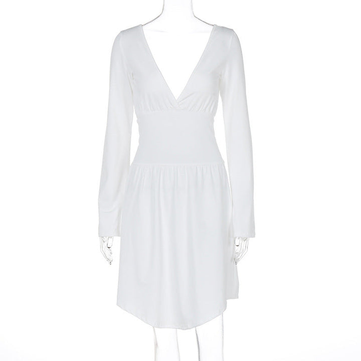 Modell iført ensfarget elegant damekjole med V-hals og lange ermer, perfekt som kveldsantrekk.