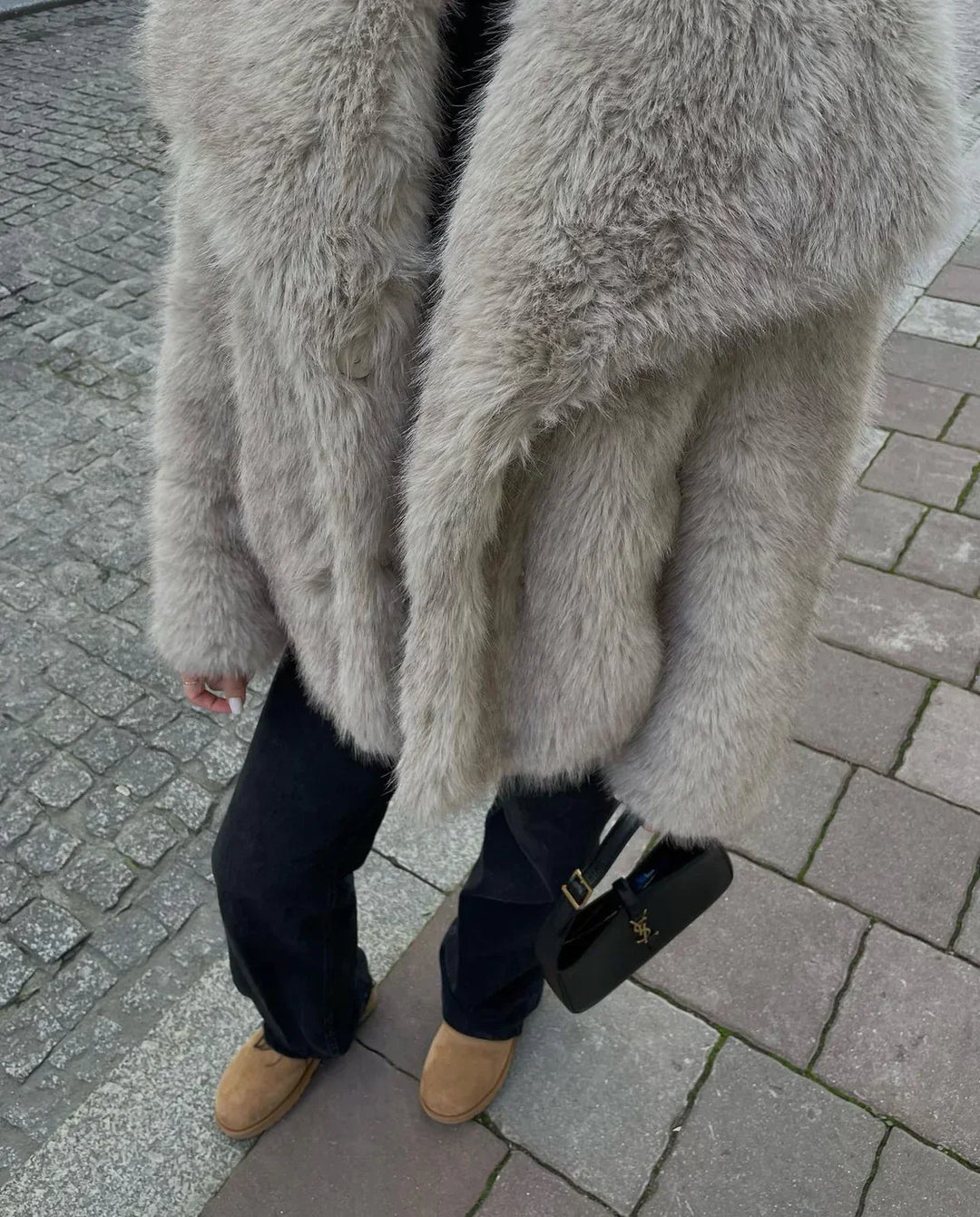Detalj av fluffy fuskepels på en elegant damejakke, som gir varme og komfort i kulden.