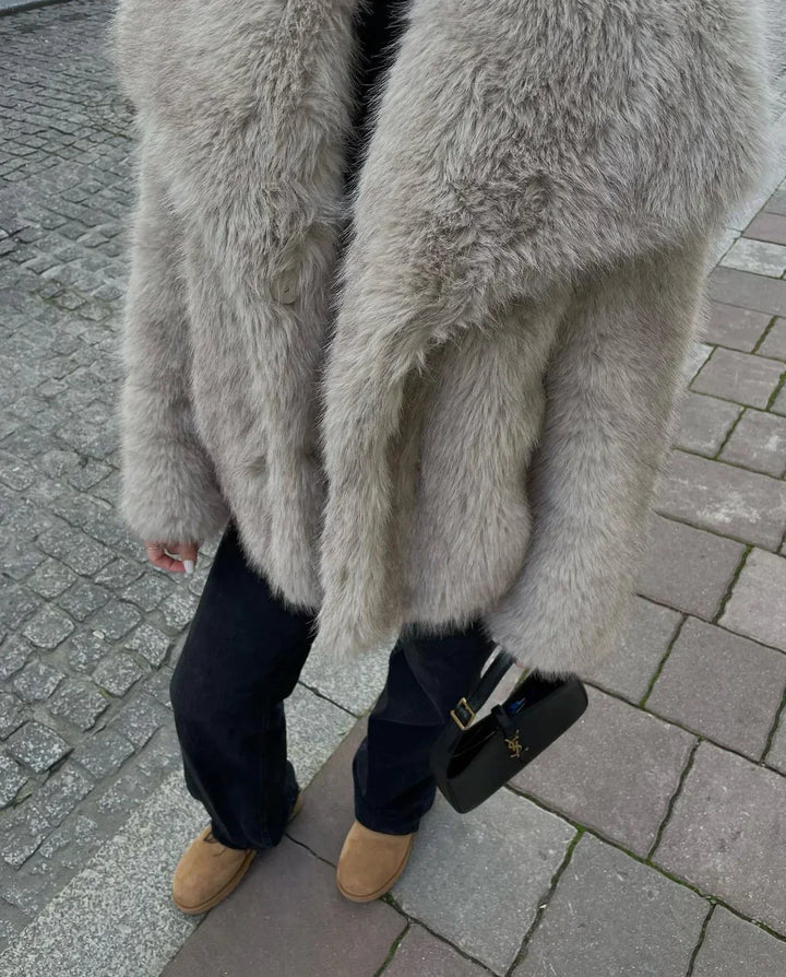 Detalj av fluffy fuskepels på en elegant damejakke, som gir varme og komfort i kulden.