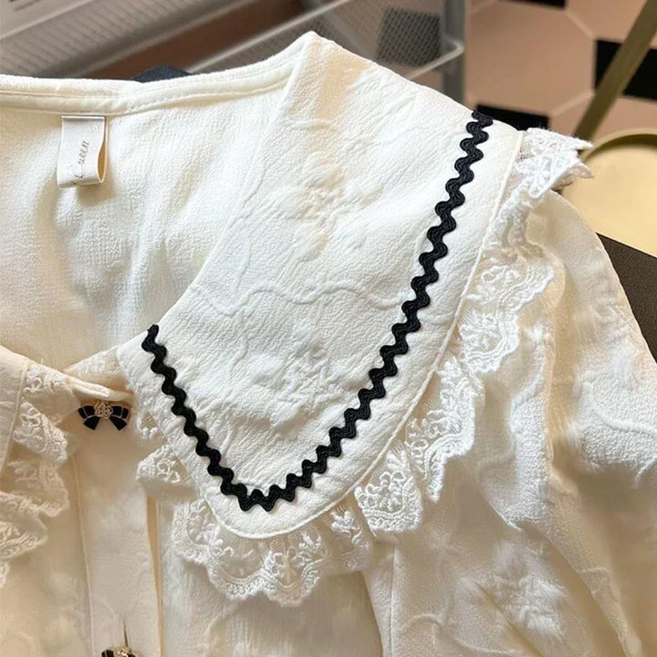 Feminin aprikos Peter Pan bluse for dame med stilige puffermer. Ideell sommerbluse i fransk stil.