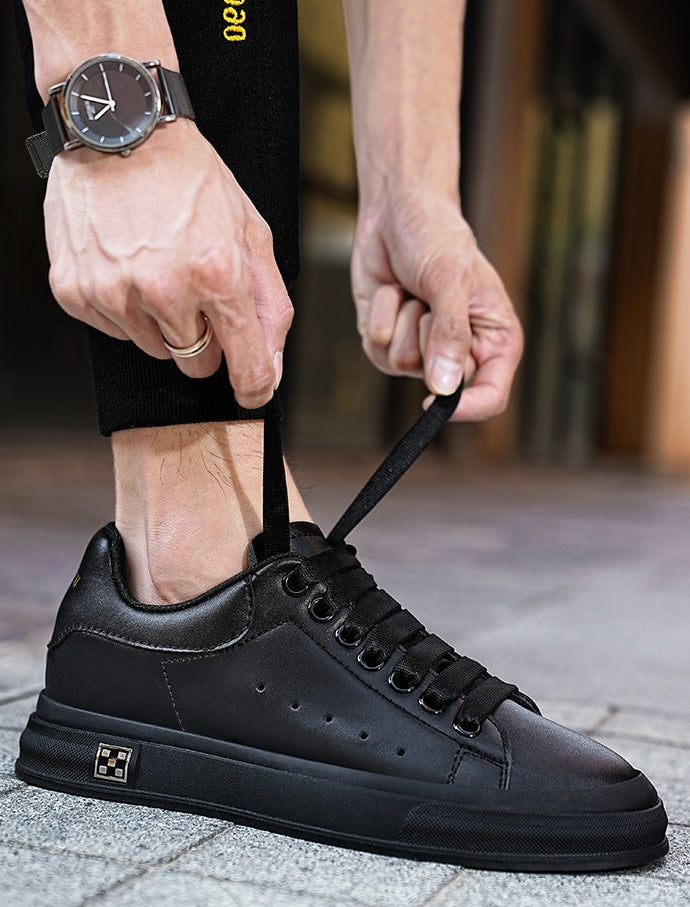 To par svarte og hvite høydeøkende herresneakers, viser 6 cm skjult hæl.