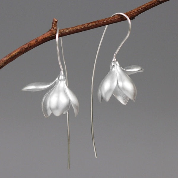 Sølvfargede magnolia blomst dingleøredobber, et allsidig og elegant smykke for kvinner.