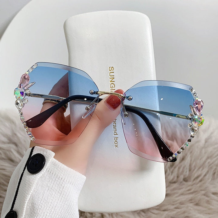 Kvinne iført luksuriøse solbriller uten ramme med strass, perfekt for en elegant sommerstil.