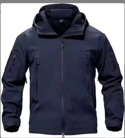 Mann i vanntett softshell jakke på tur i naturen. Varm, vindtett herrejakke med hette for vinteren.