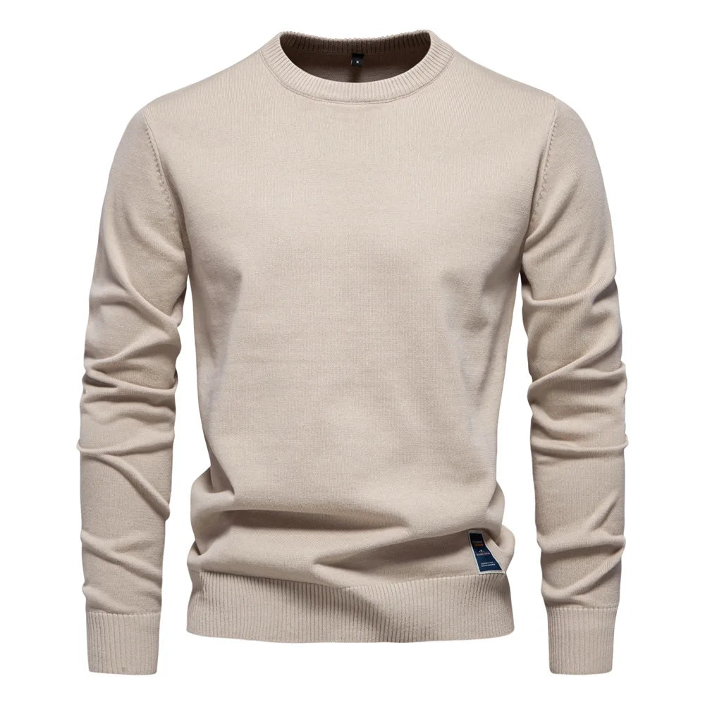 Mann iført ensfarget herregenser i ullblanding, klassisk rund hals. Avslappet og elegant stil.