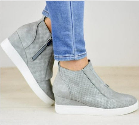 Detalj av glidelås på kile sneakers, for enkel påkledning av hverdagssko for kvinner.