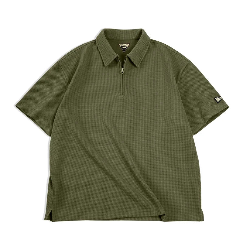Mann iført khaki vaffelstruktur polo med halvglidelås. En behagelig, casual sommertopp i vintage herremote.