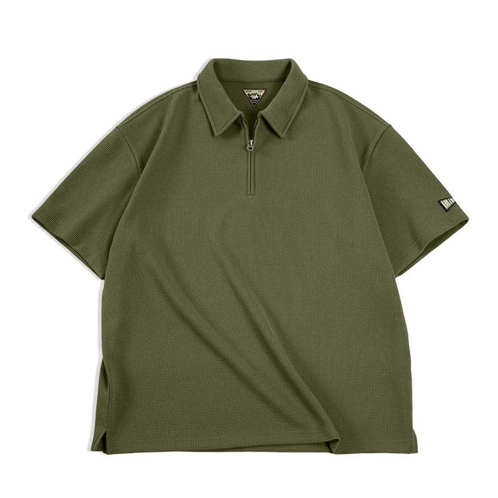Mann iført khaki vaffelstruktur polo med halvglidelås. En behagelig, casual sommertopp i vintage herremote.