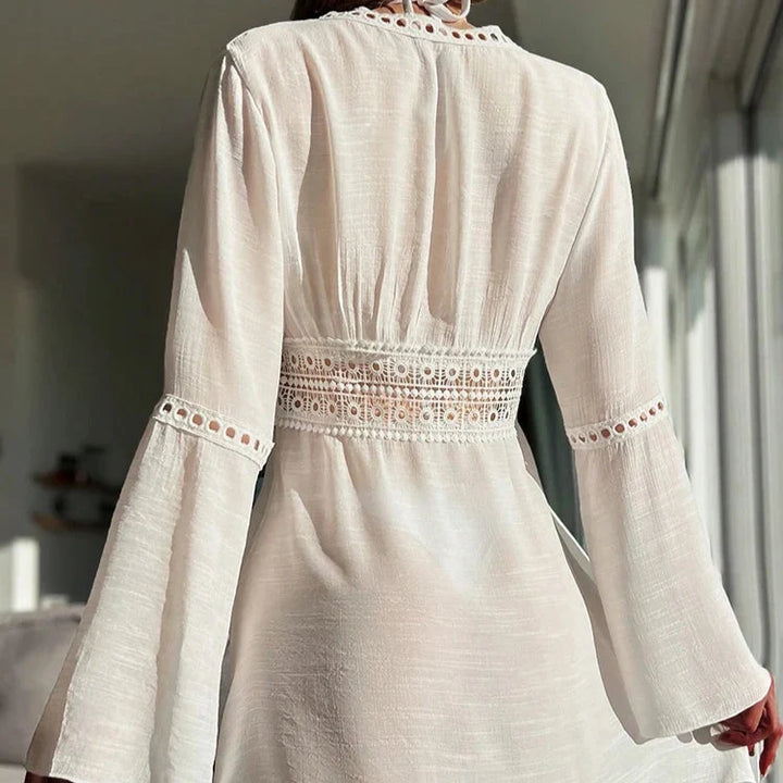 Luftig strandkjole med V-hals og blondekant. Elegant sommerkjole som lett cover-up for dame. Solbeskyttende.