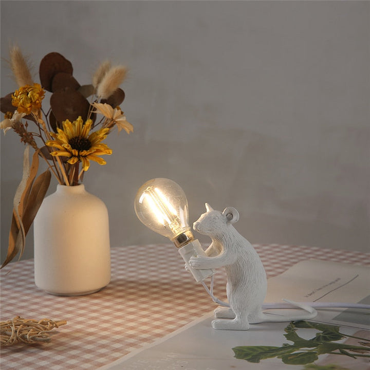 Søt harpiksfigur mus som holder en pære. Funksjonell og sjarmerende bordlampe.