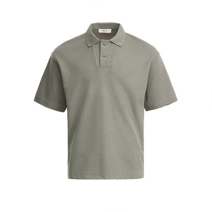 Mann iført elegant svart vaffelstrikket pikéskjorte. Komfortabel kortermet polo for fritid og sommer.