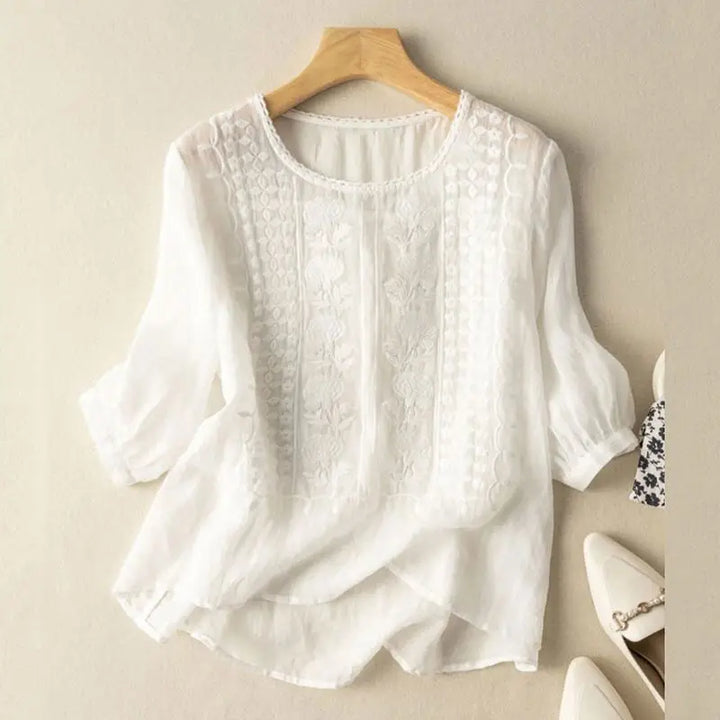 Lett, brodert damebluse med rund hals, perfekt for sommerlige hverdager og en avslappet stil.