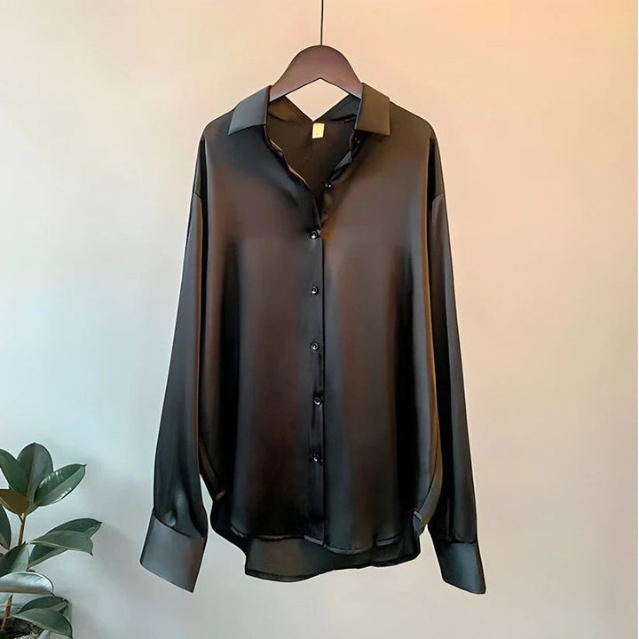 Stilren festtopp eller business casual bluse for dame, med løs passform og lange ermer.