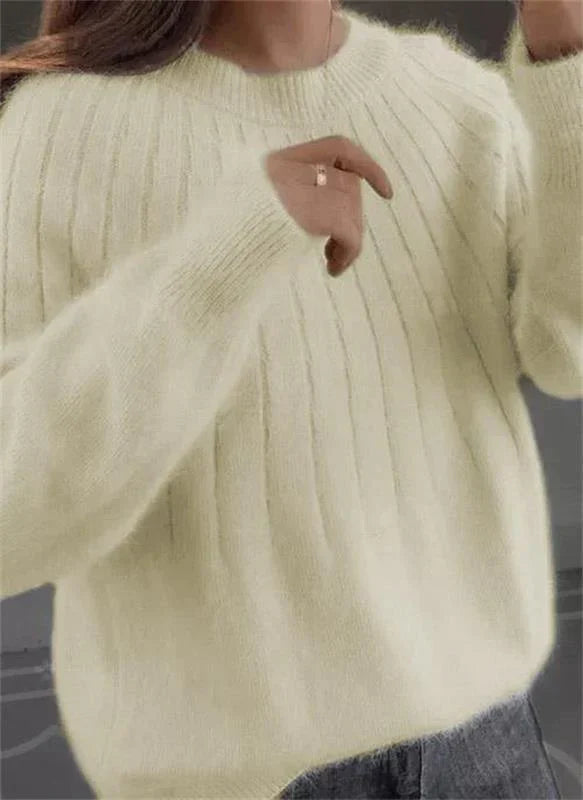 Kvinne modellerer en komfortabel og stilfull strikket genser, perfekt for elegant hverdagsbruk.