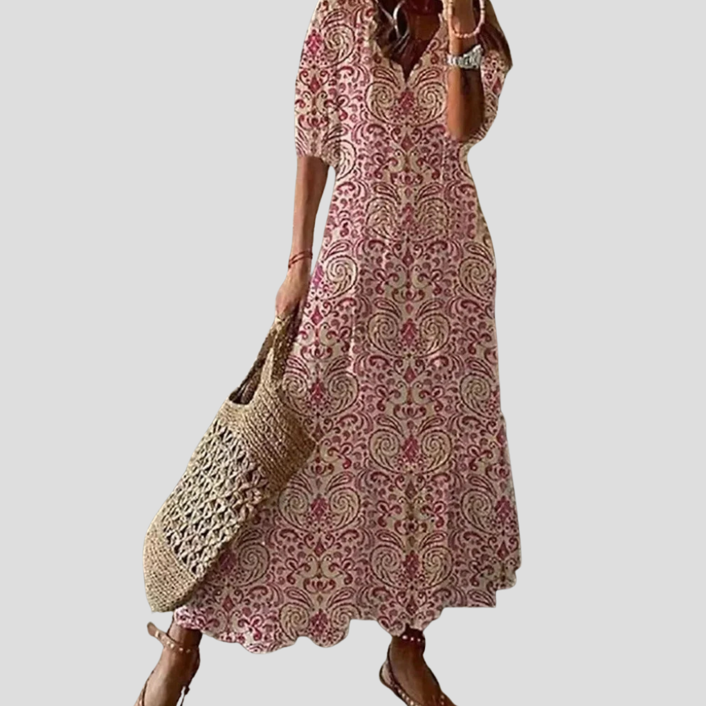 Kvinne i flytende bohemsk maxikjole. Lang sommerkjole med smock, perfekt som elegant strandkjole.