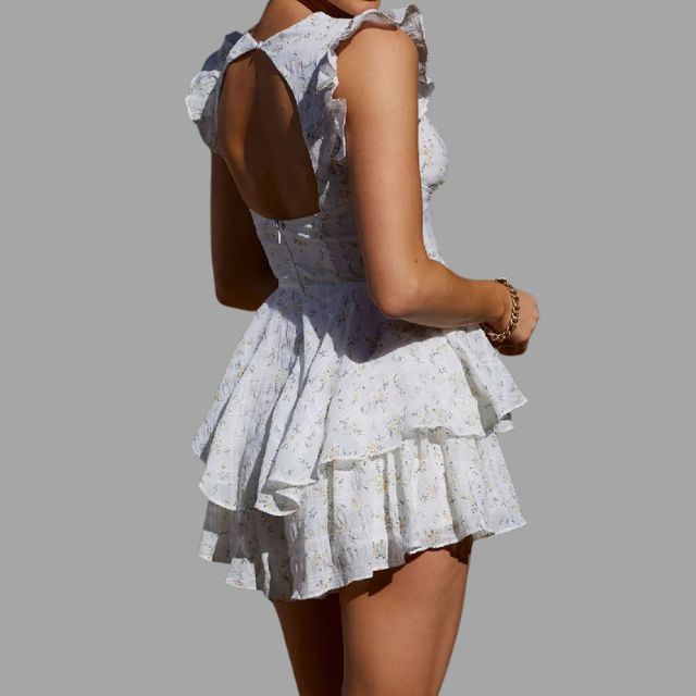 Feminine volanger og broderi på en hvit polyester damekjole. Stilig sommerkjole med V-hals for kvinner.