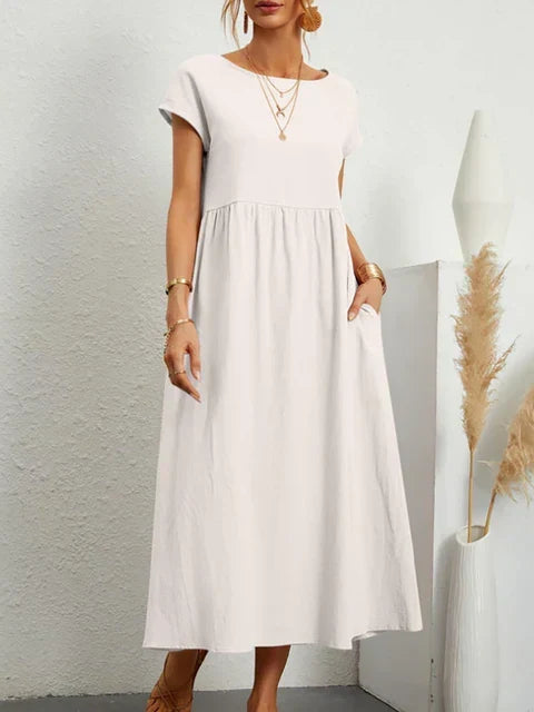 Feminine vintagekjole i bomullslin for kvinner, klassisk design med korte ermer og praktiske lommer.