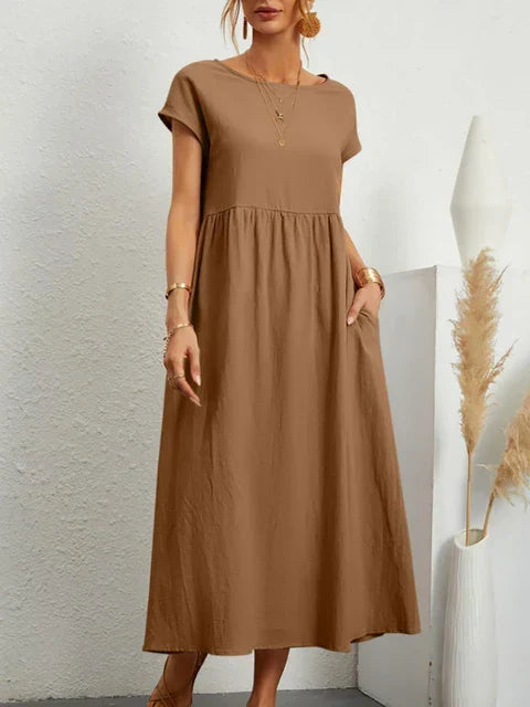 Elegant vintagekjole for kvinner, en tidløs damekjole i bomullslin med korte ermer og smarte lommer.