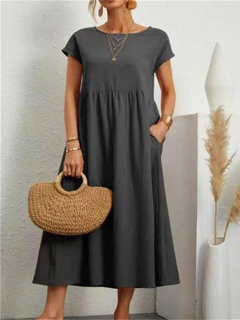 Elegant sommerkjole/vårkjole i bomullslin med feminint snitt, korte ermer og lommer. Perfekt for fritid.