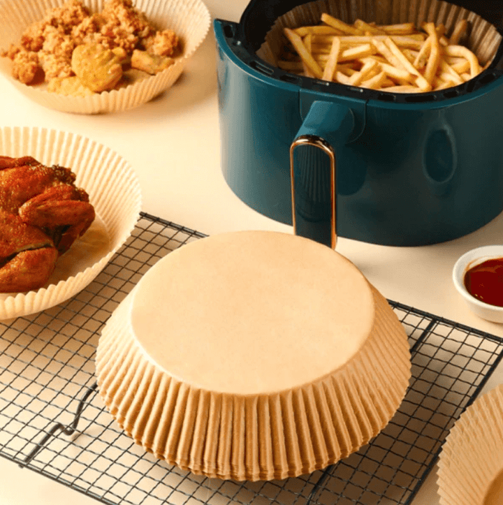 Airfryer bakepapirfôr med mat. Forhindrer søl og sikrer enkel rengjøring etter matlaging.
