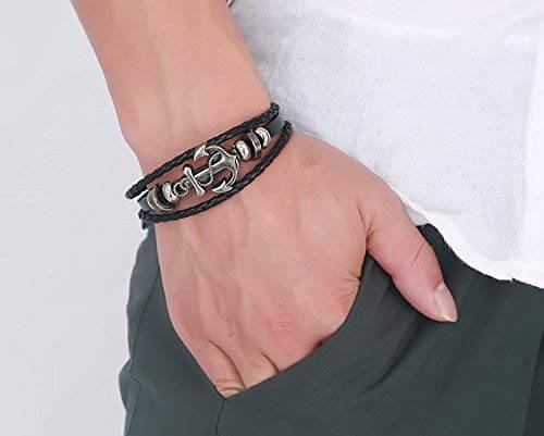 Nautisk skinnarmbånd med anker båret på håndleddet. Trendy maritimt armbånd for herre og dame.