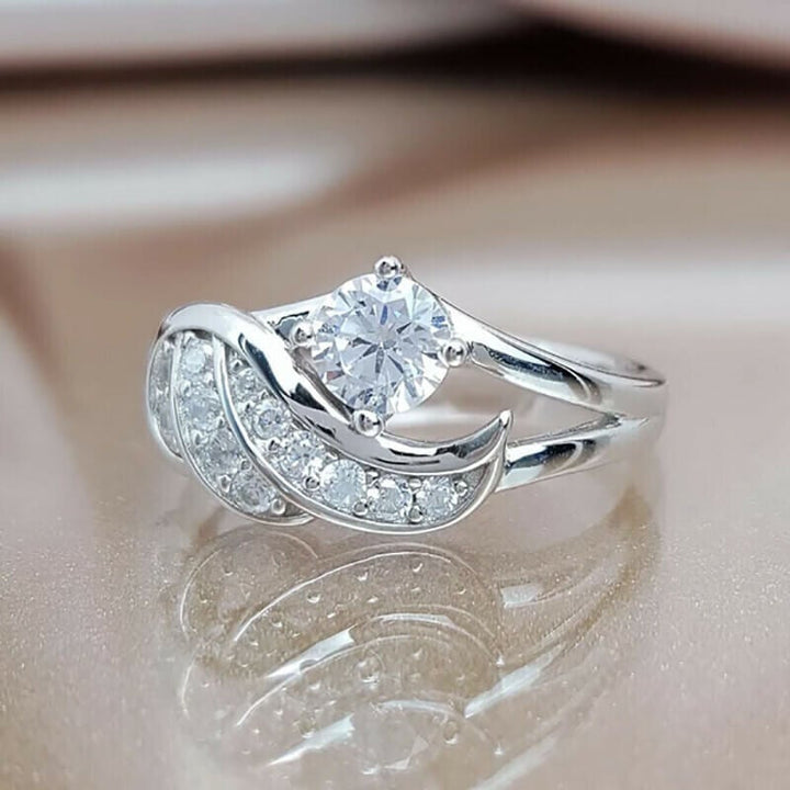 Håndlaget dame ring med finpusset englevinge og glitrende cubic zirconia krystaller.