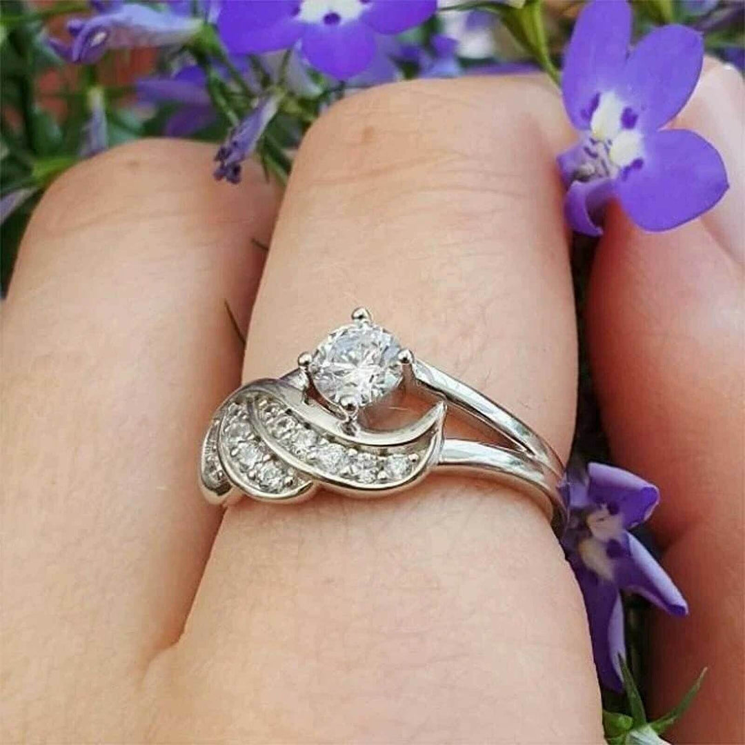 Nærbilde av dame ring med englevinge og tettpakket cubic zirconia. Maksimal glans.