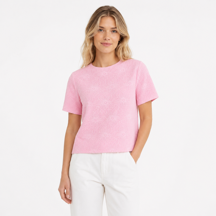 Elegant rosa strikket topp for dame, med delikat floral jacquardmønster og mockneck. Perfekt slimfit sommeroverdel.