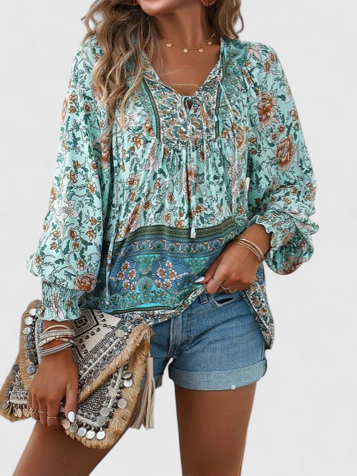 Elegant damebluse med V-hals, puffermer og et romantisk blomstertrykk. Komfortabel boho-stil.