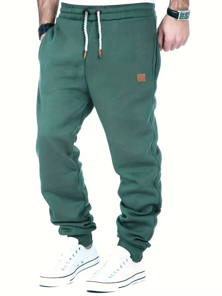 Moderne marineblå herre joggebukse med elastisk midje og snøring for maksimal komfort.
