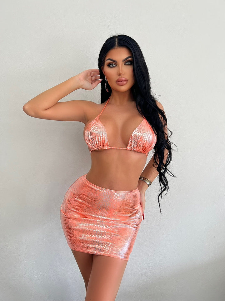 Dame nyter sommeren i en trendy 3-delt badedrakt med elegant slangemønster. Klar for stranden.
