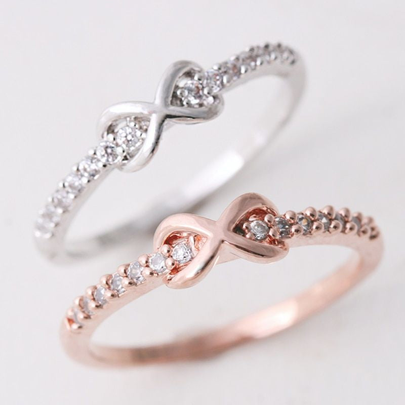 Nærbilde av elegant infinityring i sølv på finger, smykke til dame og datter.