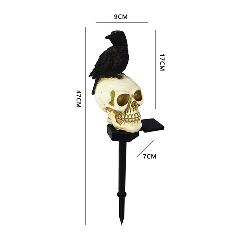 Gotisk hodeskalle og kråke solcellelampe. Effektfull hagedekorasjon, utendørs stemningslys til Halloween.