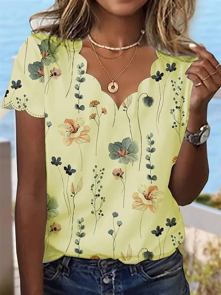 Vår- og sommerbluse med lekent blomstertrykk, perfekt for en casual look.