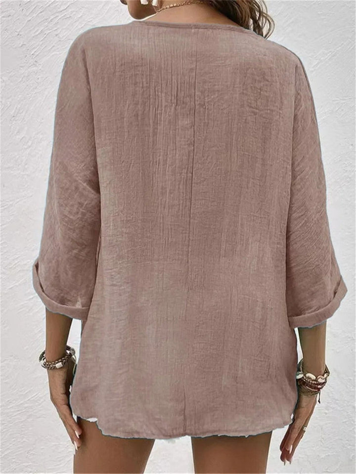 Allsidig V-hals damebluse i bomull, med trekvart ermer. Passer til casual og elegant sommerstil.