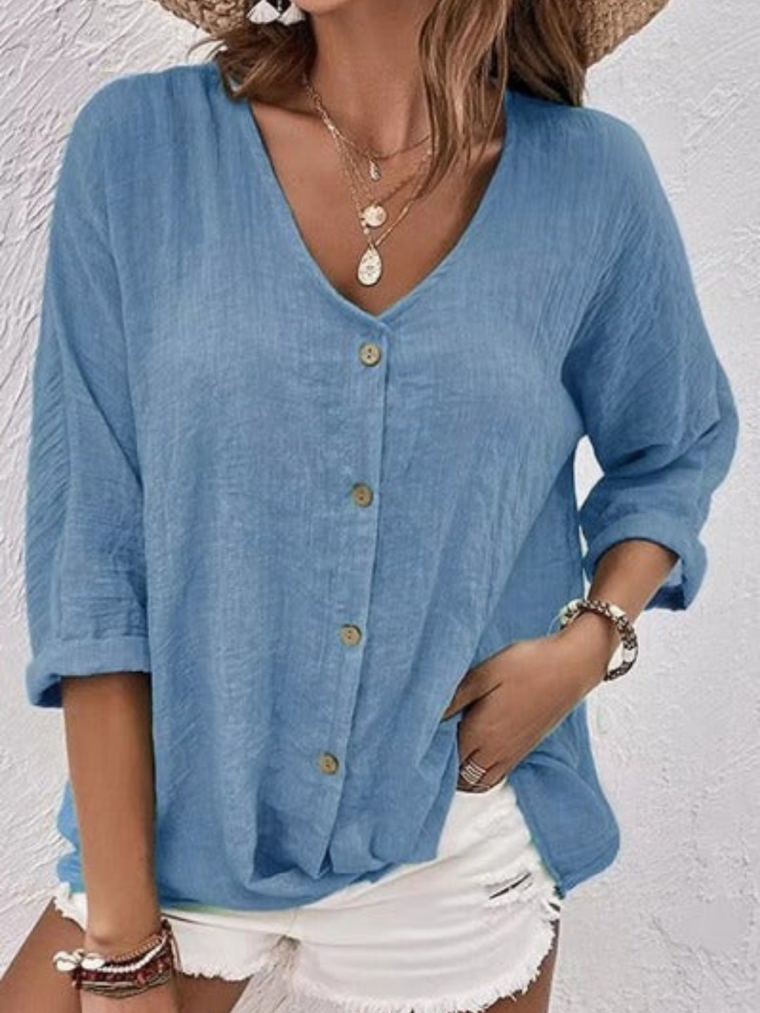 Stilren kvinnebluse med V-hals og trekvart ermer. Komfortabel bomull for en løs og elegant hverdag.
