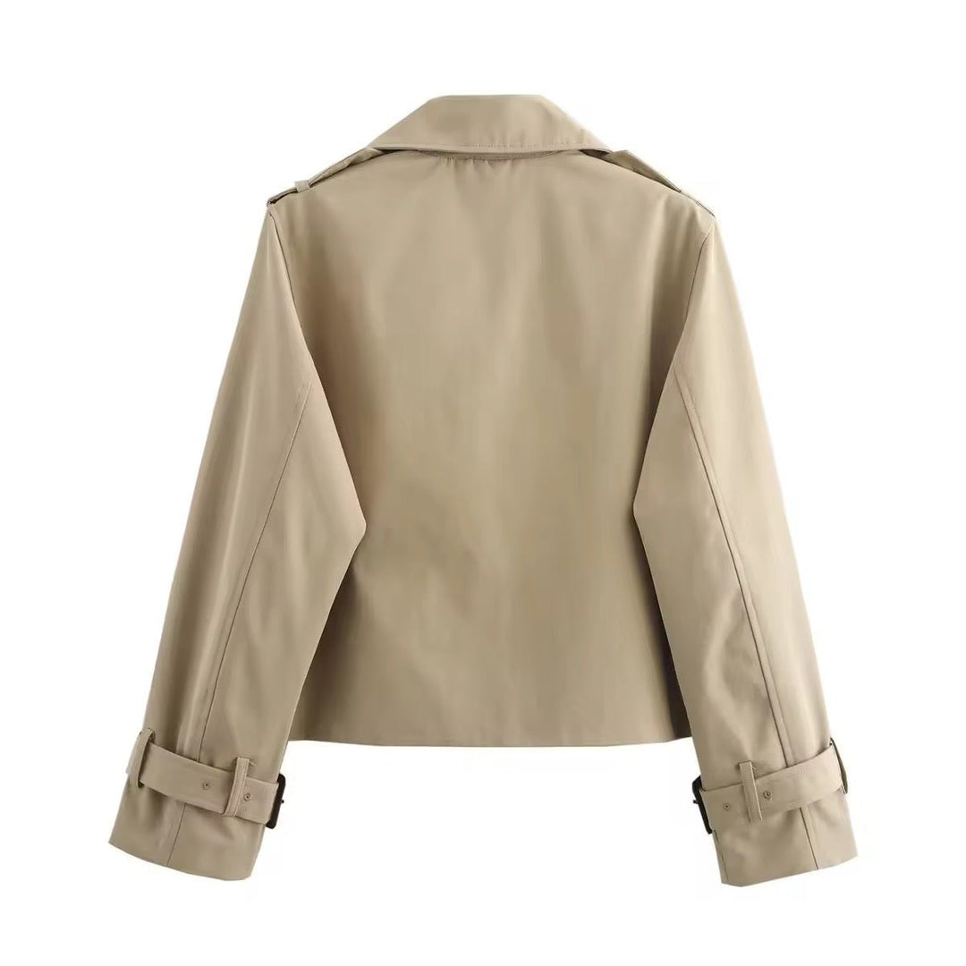 Klassisk kort trenchcoat til kvinne. Tidløst dobbeltspent ytterplagg med belte, ideelt for alle anledninger.