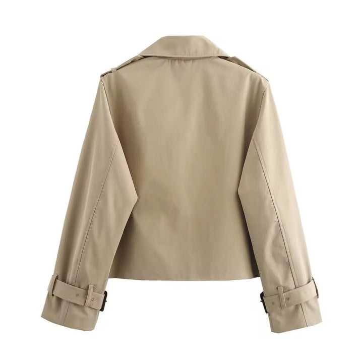 Klassisk kort trenchcoat til kvinne. Tidløst dobbeltspent ytterplagg med belte, ideelt for alle anledninger.