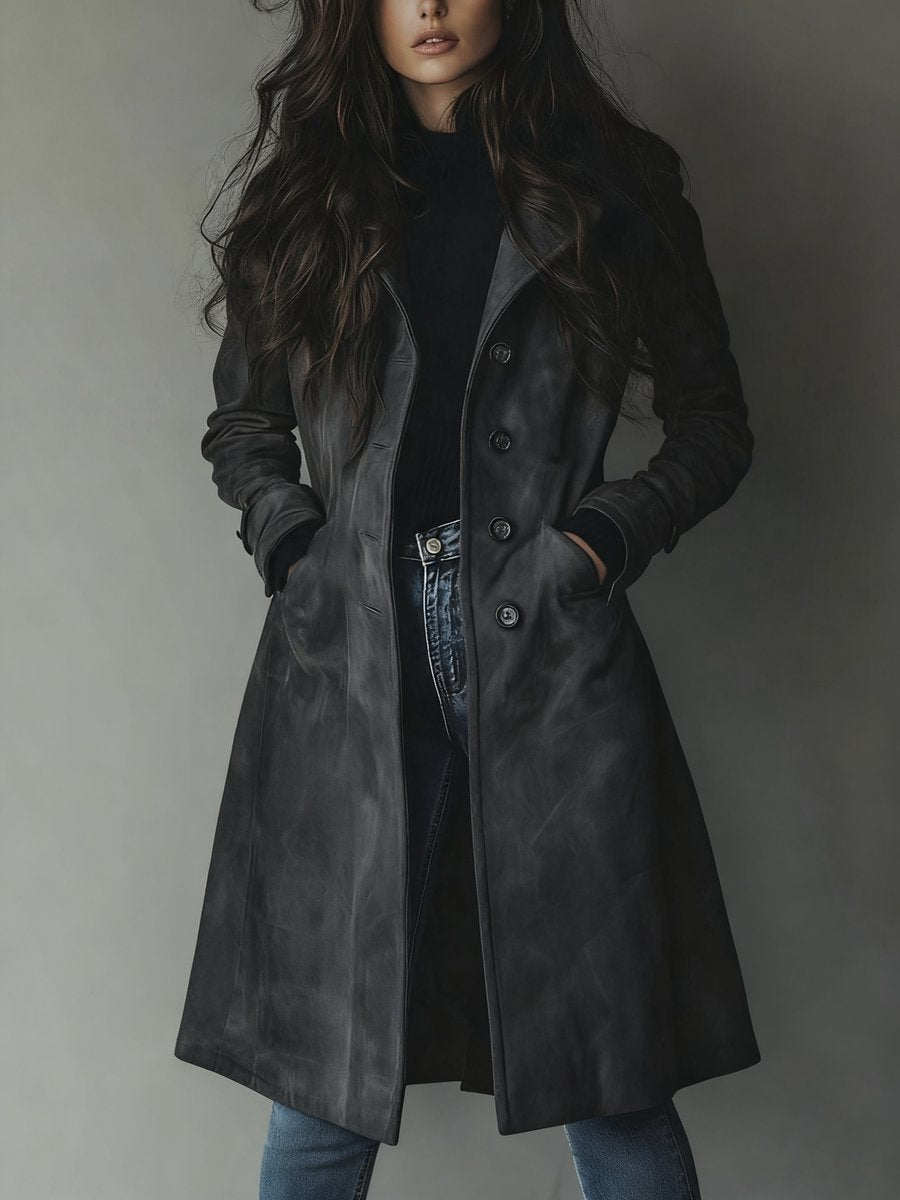 Kvinne i stilfull lang dobbelspent trenchcoat, perfekt som yttertøy for kjølige dager eller kvelder.