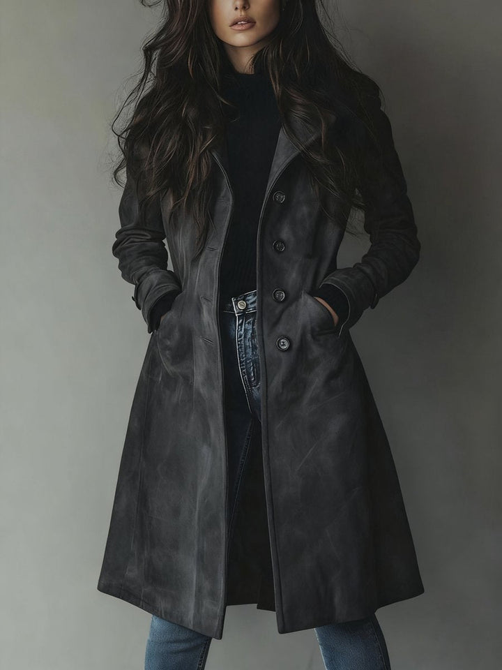 Kvinne i stilfull lang dobbelspent trenchcoat, perfekt som yttertøy for kjølige dager eller kvelder.