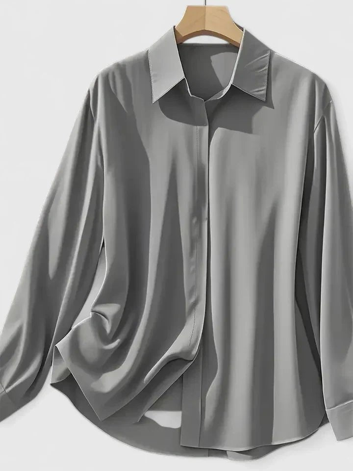 Kvinnebluse med lang erm, i skinnende satin, og elegant skjult knapplukking.